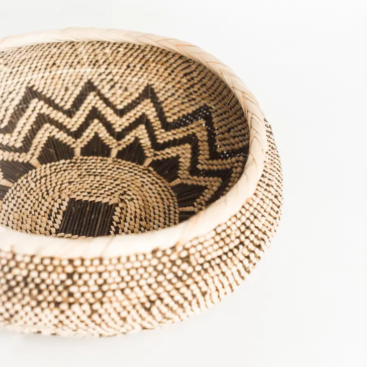 Hand-woven basket in natural color with brown sun design