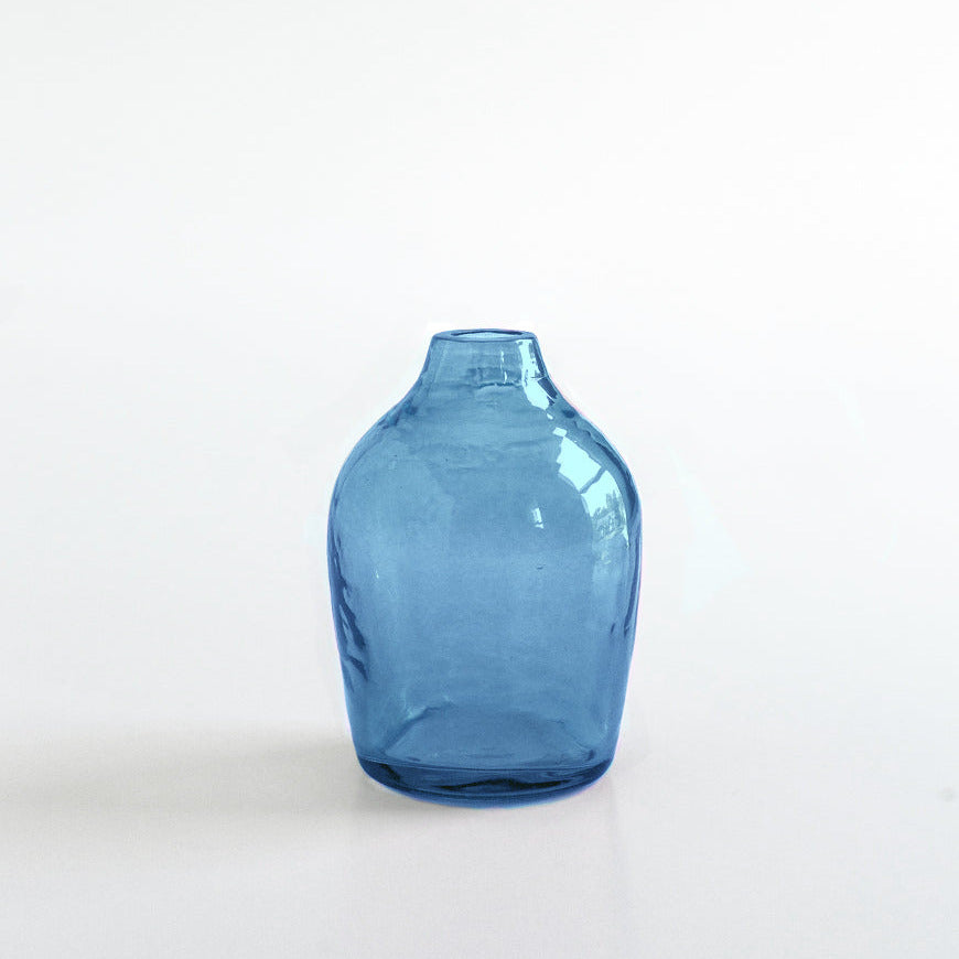 Blue handblown hammered glass vase on a white background