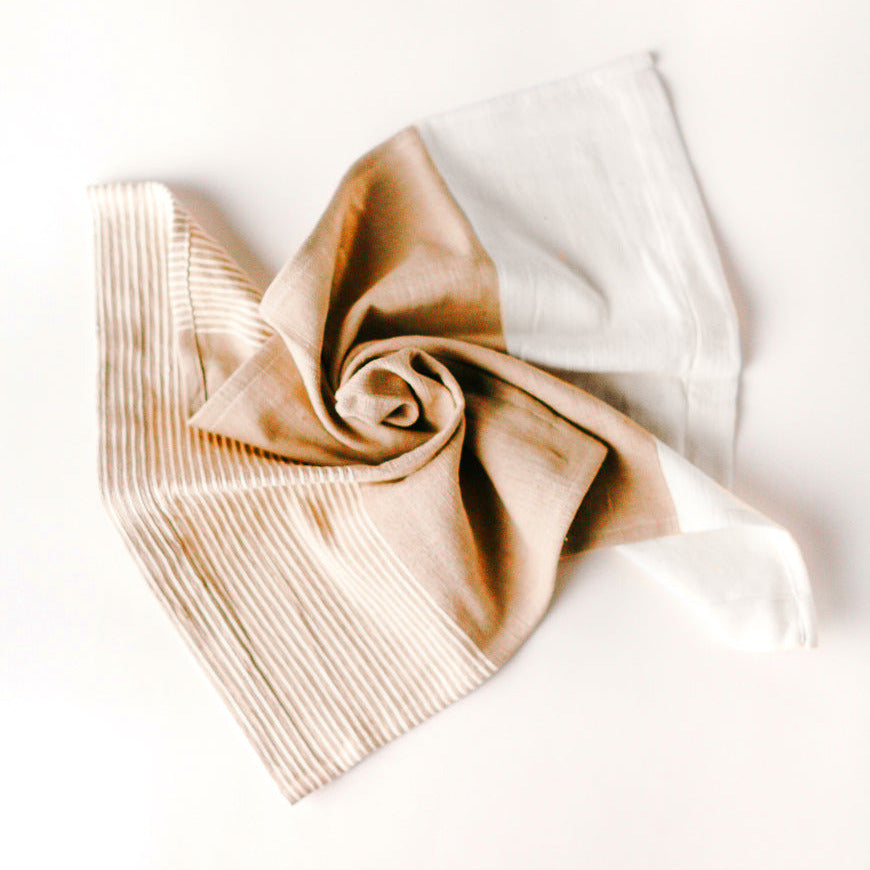 Folded beige and white towel on a light background