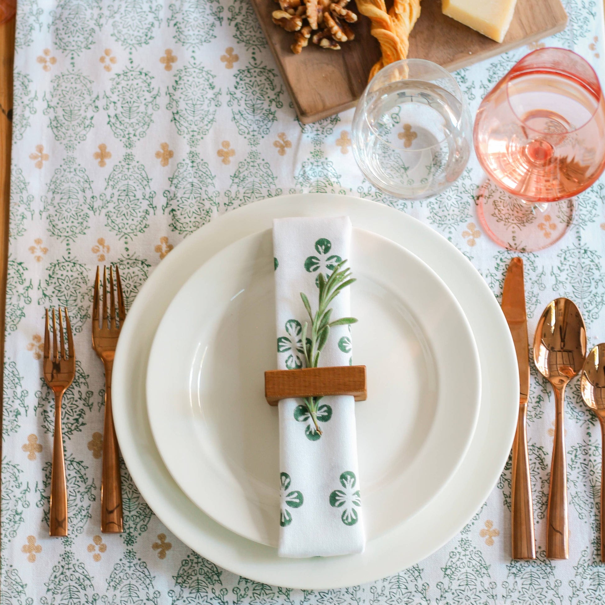 placesetting with white plates handcarved napkin ring and cotton napkins with green dogwood design