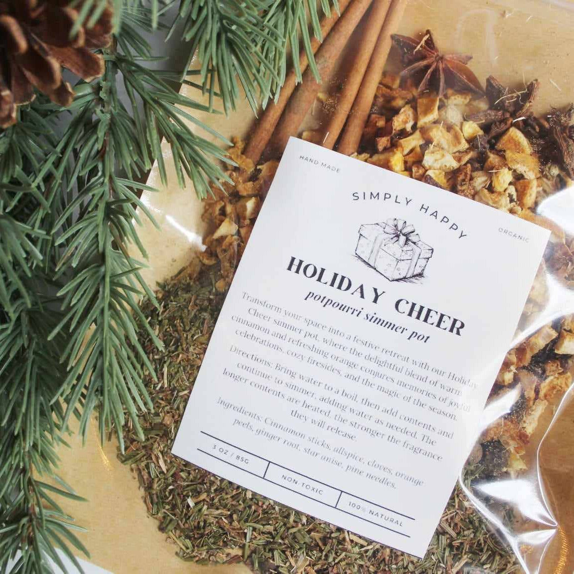 Potpourri mix with cinnamon sticks, pine cones, and a label on a gold tray.