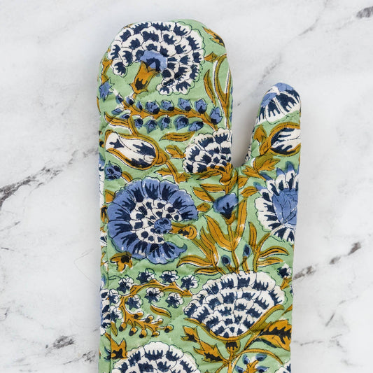 Floral blue and mint hand blocked patterned oven mitt on a marble surface