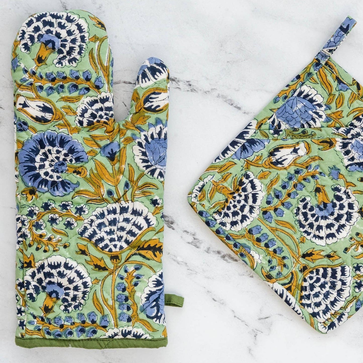 Floral blue and mint block printed patterned oven mitt and pot holder on a marble surface