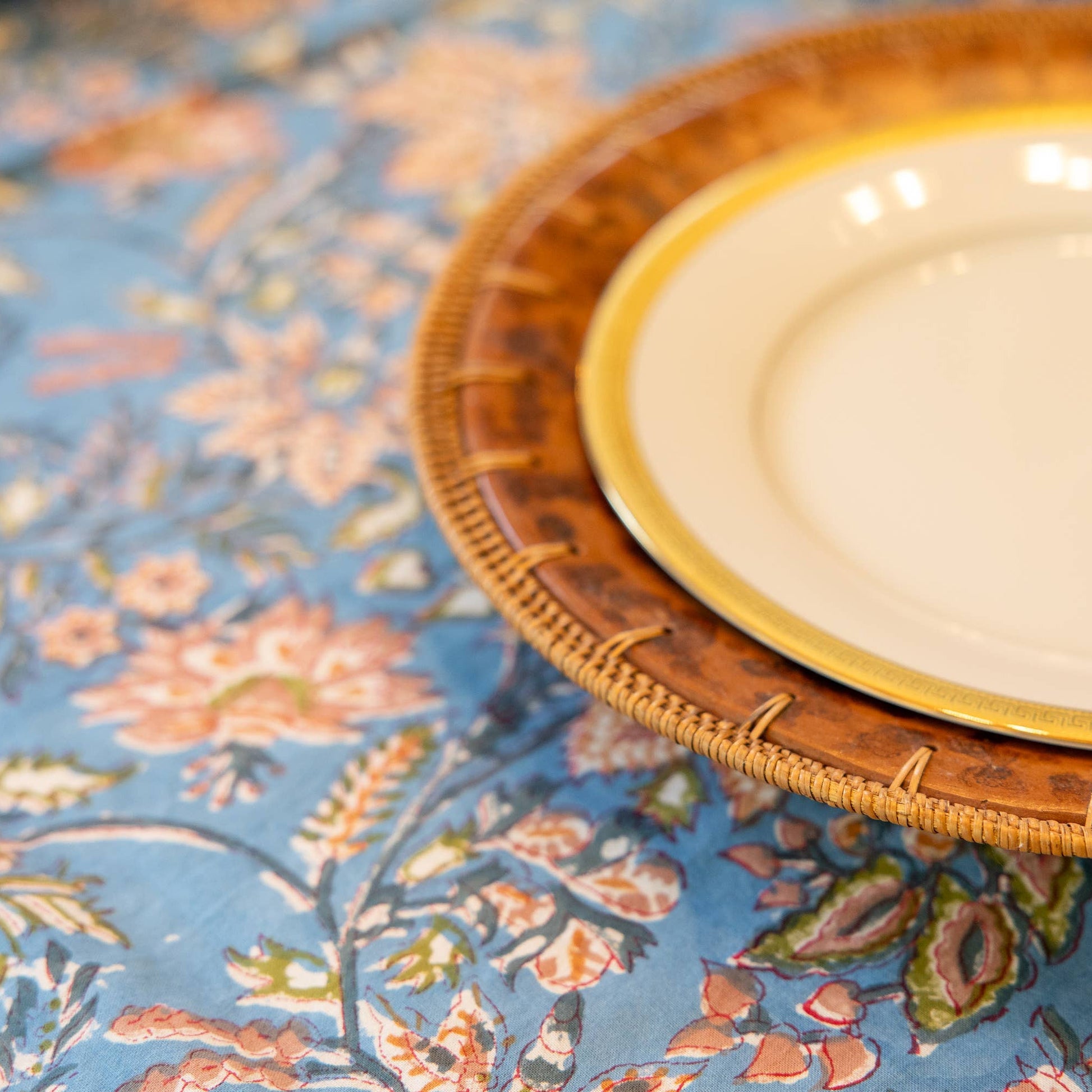 White plate with gold rim on a decorative handblocked tablecloth