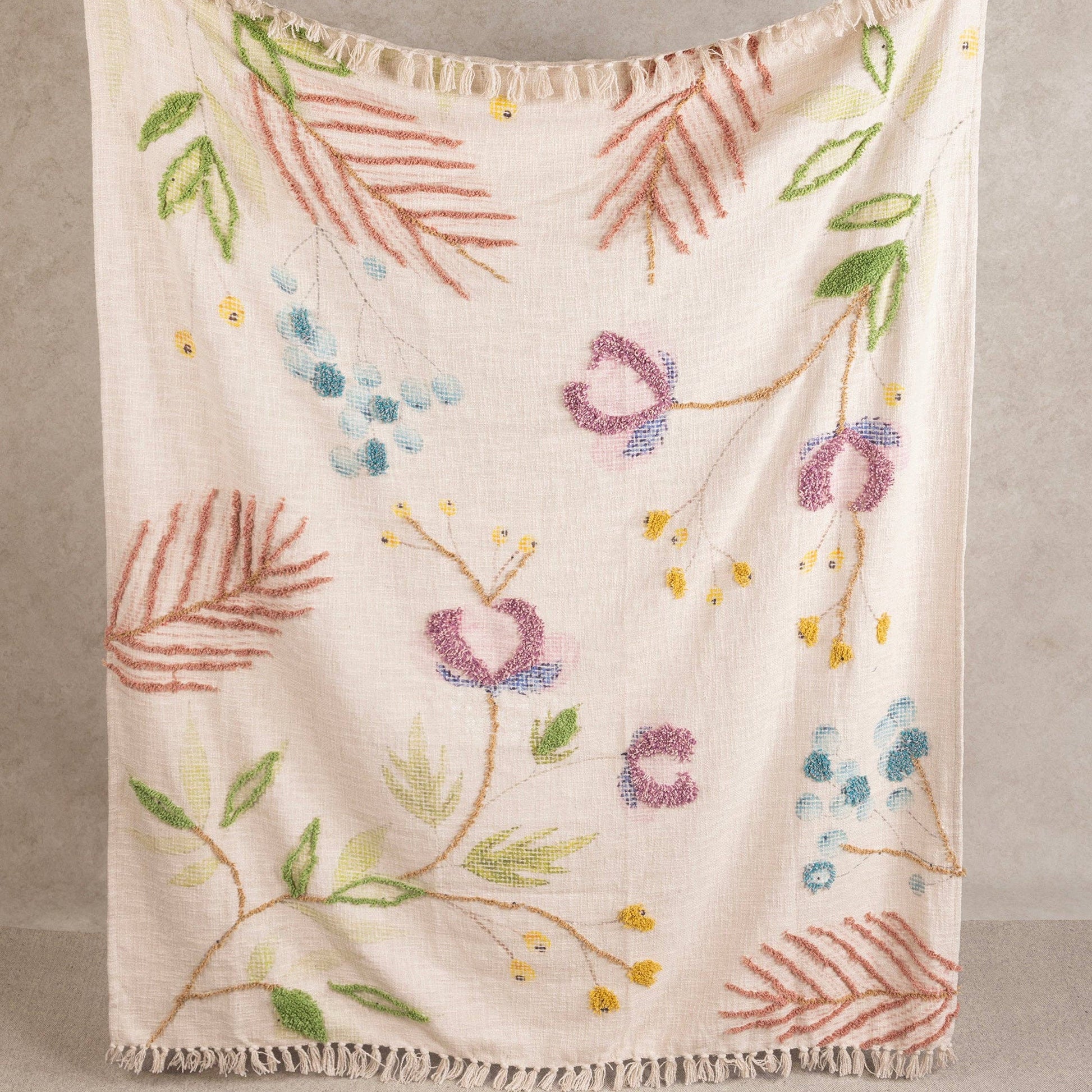 Embroidered floral blanket with colorful patterns on a neutral background