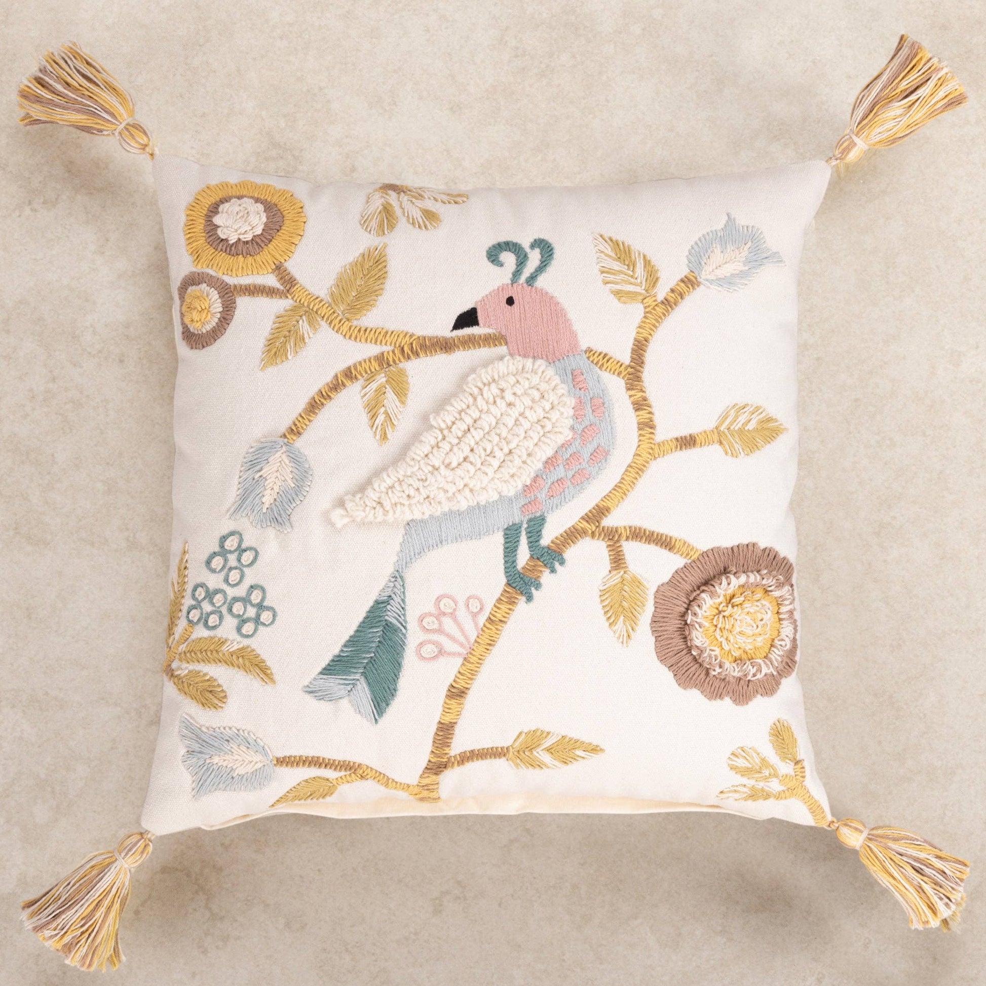 handmade decorative pillow with bird and floral embroidery on a beige background