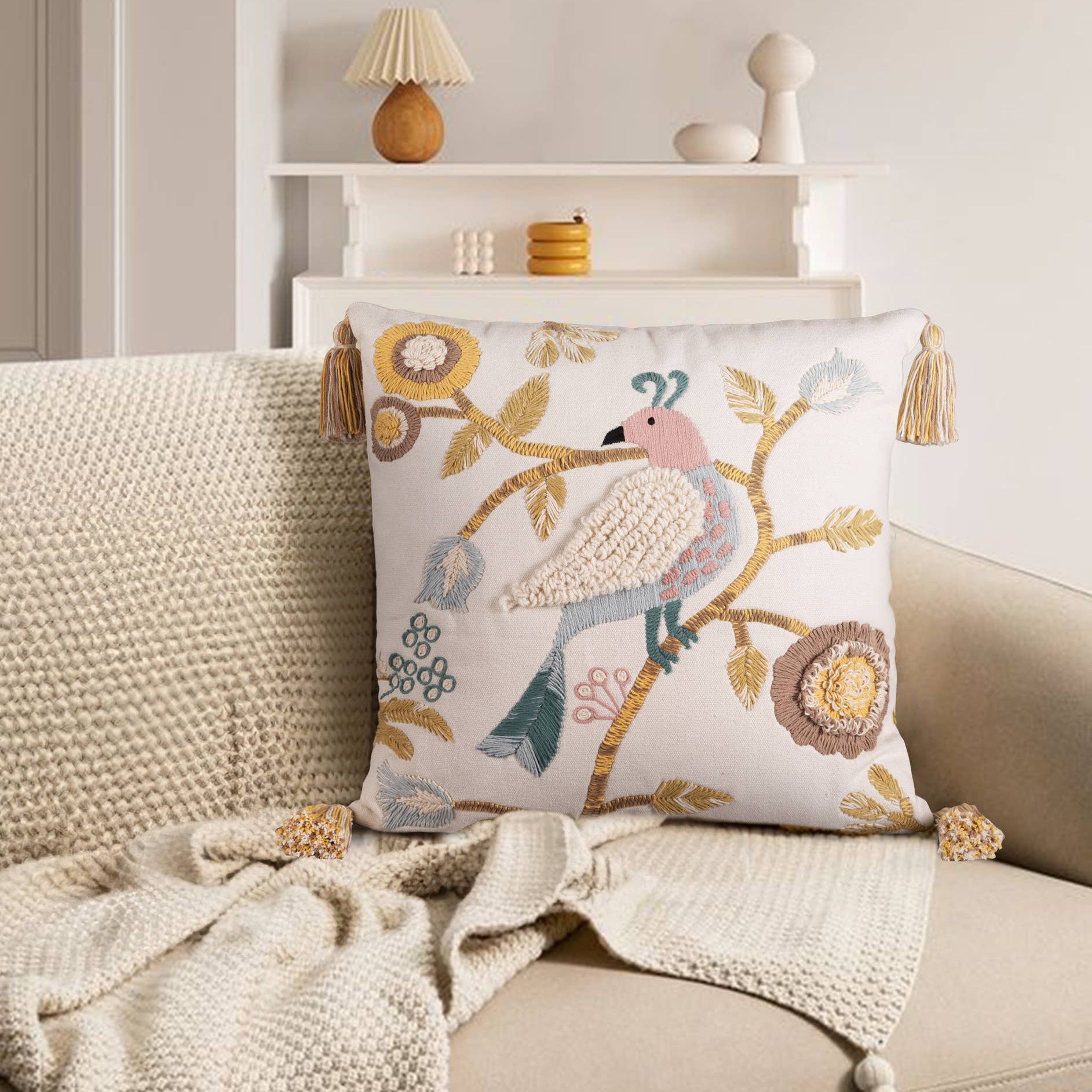 hand embroidered decorative pillow with bird design on a sofa in a living room setting