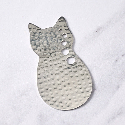 Cat-shaped stainless steel herb stripper  on a white marble surface