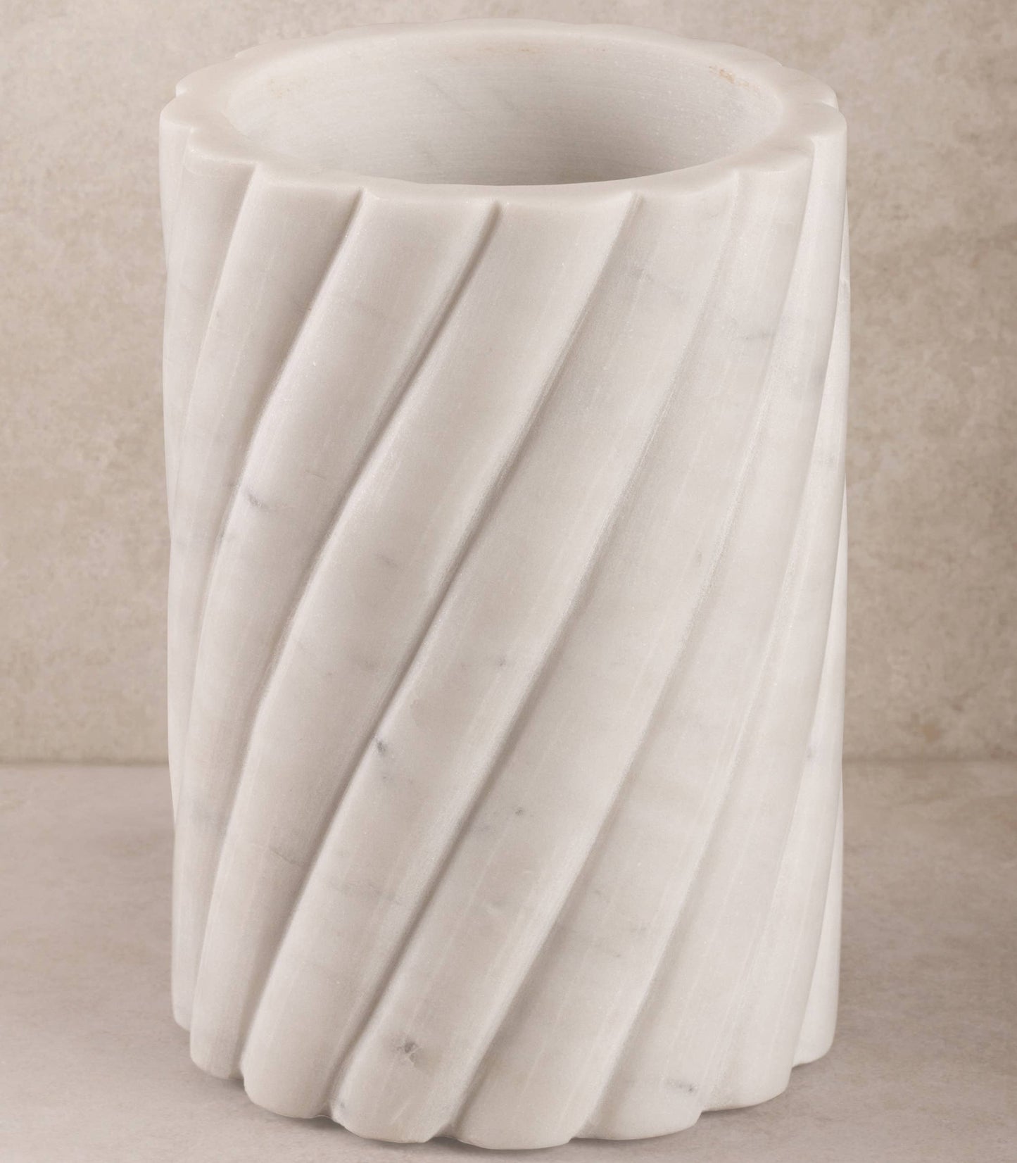 White marble wine cooler with textured surface on a beige background