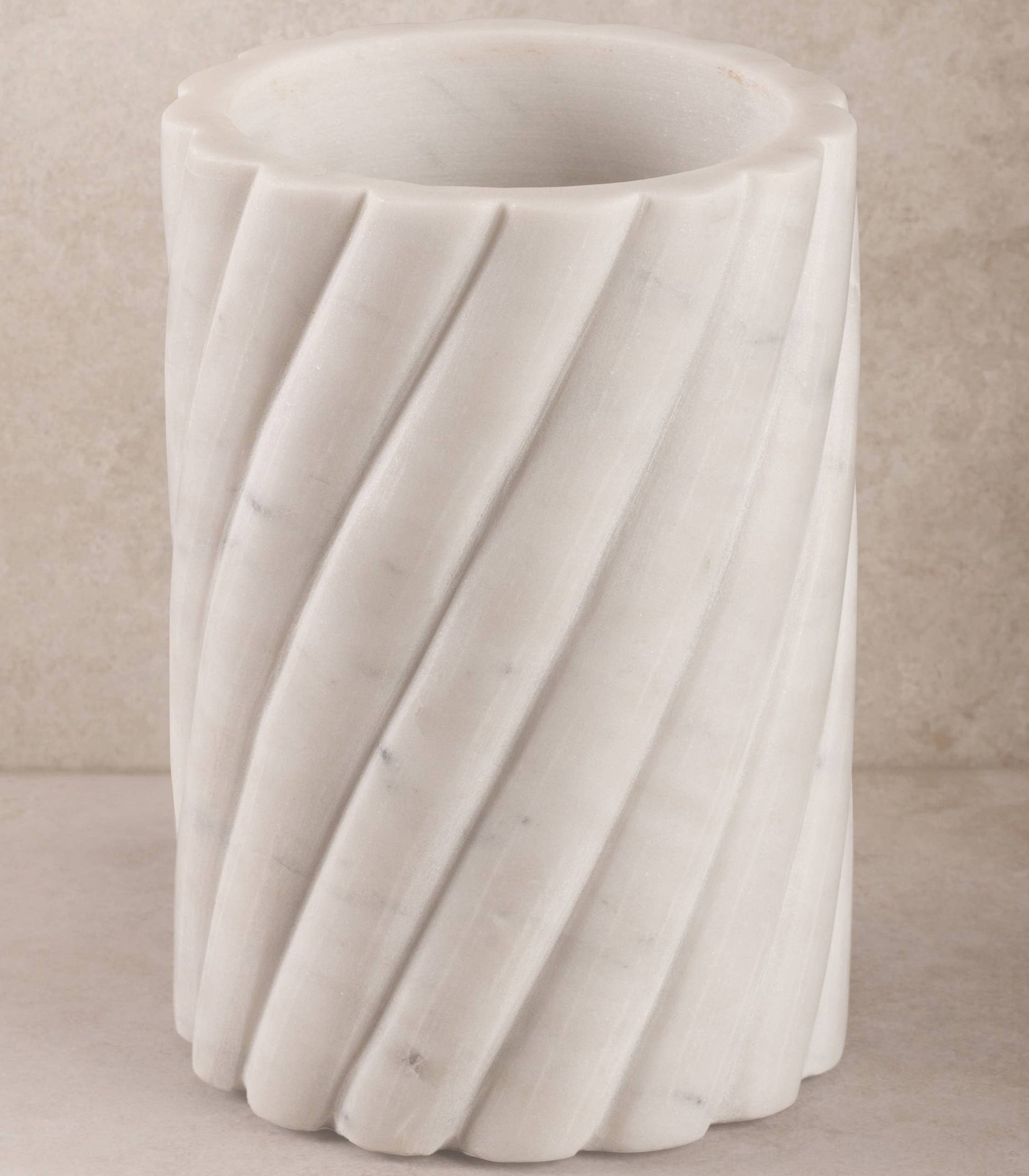 White marble wine cooler with textured surface on a beige background