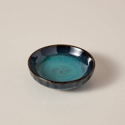 Handmade mini Ceramic bowl with blue glaze on a beige background