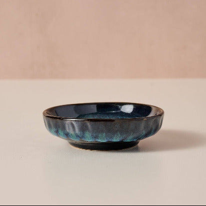 handmade small blue ceramic bowl on a beige background