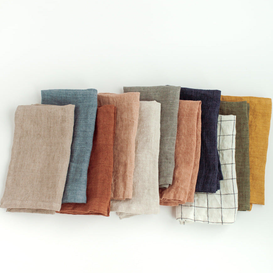 Set of folded fabric napkins in various colors on a white background